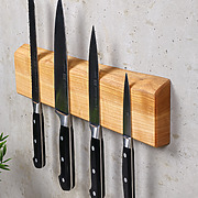 Detailaufnahme der Stirnseite einer magnetischen Messerleiste aus Kirschholz mit natürlicher Baumkante und Maserung