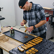 Holzöl wird mit OLI-NATURA Ölpinsel gleichmäßig auf handgefertigten Holz-Flaschenöffner aufgetragen