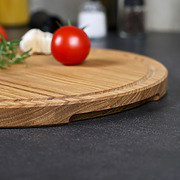 Detailaufnahme der Griffmulde eines runden Pizzabrettes aus Eichenholz, fein geschliffen und hochwertig verarbeitet