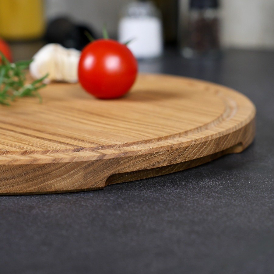 pizzabrett-rund-eiche-handgefertigt-3 Detailaufnahme der Griffmulde eines runden Pizzabrettes aus Eichenholz, fein geschliffen und hochwertig verarbeitet