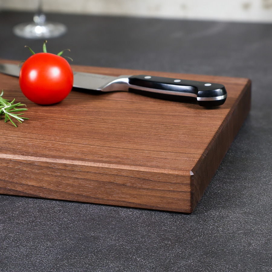 schneidebrett-amerikanische-nuss-handgefertigt-4 Detailaufnahme der natürlichen Holzmaserung und der elegant gefasten Kante eines handgefertigten Schneidebrettes aus amerikanischem Nussbaum