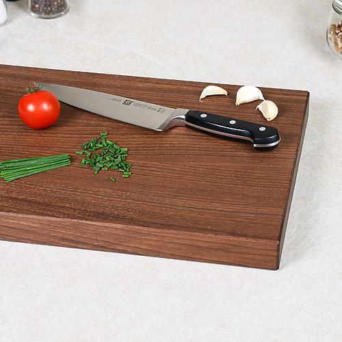 Schneidebrett aus amerikanischem Nussbaum mit Tomaten, Küchenkräutern und Messer