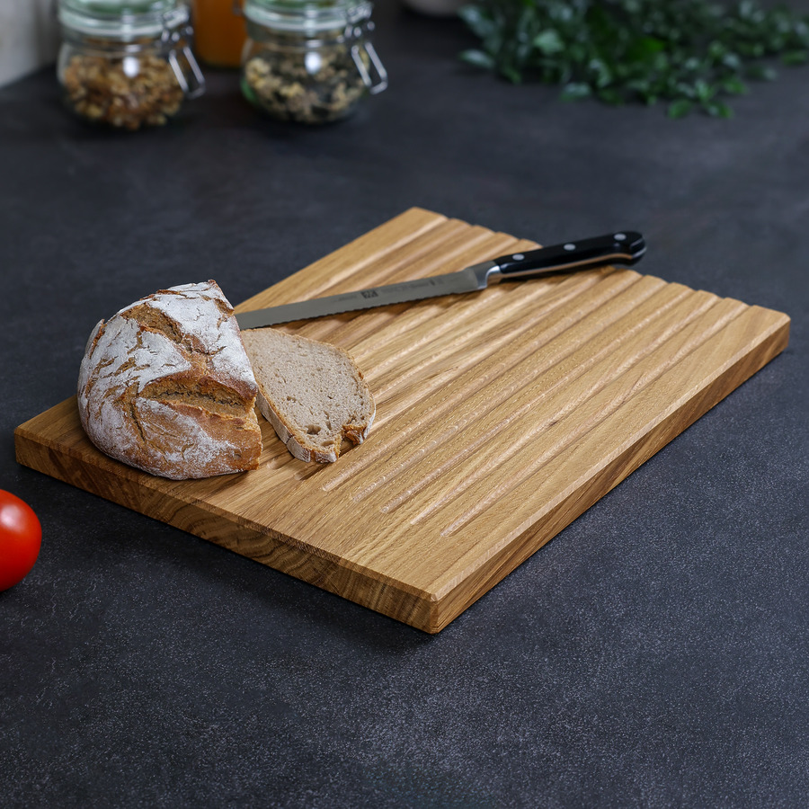 schneidebrett-brot-eiche-handgefertigt-3 Brotschneidebrett aus Eiche mit Krümelmulden, Brotlaib und Messer auf der Arbeitsfläche