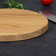 Nahaufnahme der natürlichen Holzmaserung und der elegant gefasten Kante eines handgefertigten Schneidebrettes aus Eiche